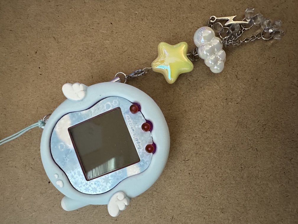 image of puple tamagotchi uni in a blue angel-themed case